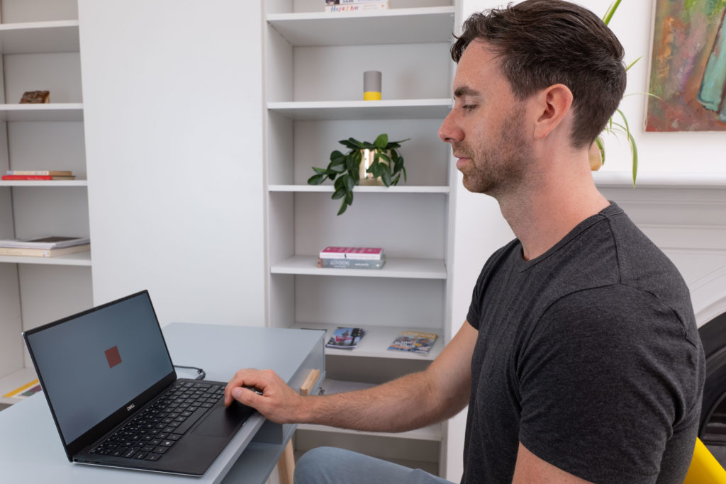 Man sat at a table using a laptop