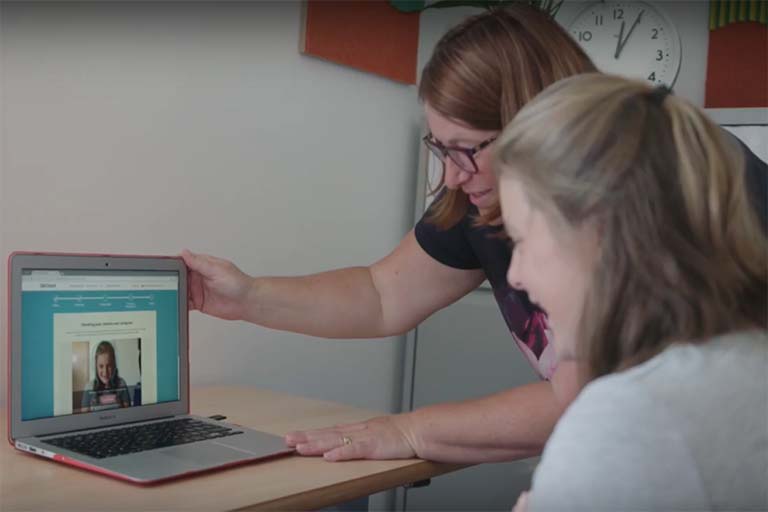 Clinician using a laptop with a patient